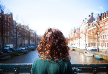 Fototapeta na wymiar Pretty girl on a canal in Amsterdam