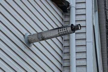 one gray chimney from a metal pipe on a plastic wall