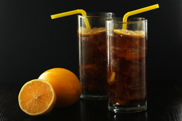 Glasses with cuba libre cocktail or cola with ice or cold tea with lemon	