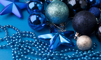  Christmas  festive blue background, on which lies a lot of different blue Christmas tree toys with gifts and beads