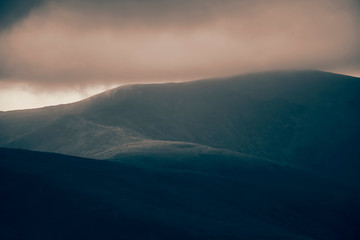 Dramatic scene of thunderstorm in dark stormy sky in mountains.