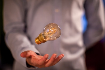 Businessman levitates a light bulb