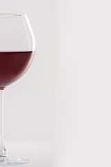 Glass of red wine on a white background and with soft shadow. There is a place for text.