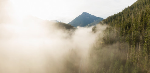 Aerial Panoramic View of Beautiful Canadian Mountain Landscape above the clouds during a sunny day. Located on the West Coast of Vancouver Island near Tofino and Ucluelet, British Columbia, Canada.