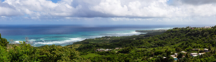 Fototapeta na wymiar Beautiful Panoramic View of the Caribbean Sea from top of a hill during a sunny and cloudy day. Church View, Saint John, Barbados.