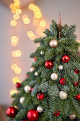 Beautiful small Christmas tree on wooden table. Happy mood. Garland lamp bokeh on background. Wallpaper. Danish pine and fir, Nobilis