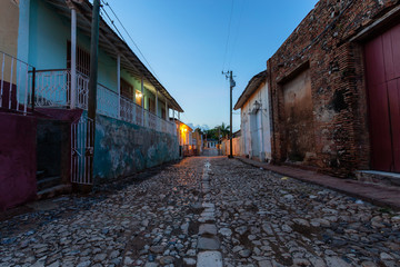 Fototapeta na wymiar Trinidad, Cuba. Street view of a Residential neighborhood in a small Cuban Town during a cloudy and sunny sunrise.