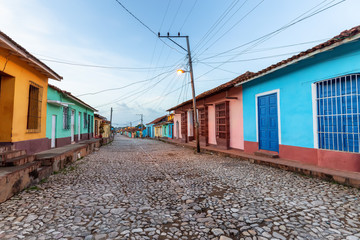 Fototapeta na wymiar Street view of a Residential neighborhood in a small Cuban Town during a cloudy and sunny sunrise. Taken in Trinidad, Cuba.