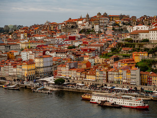 Fototapeta na wymiar Porto, Portugal. 16 November 2019. Colorful skyline of the old town at sunset seen from other side of river Douro.