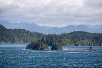 Fototapeta na wymiar Northern Vancouver Island, British Columbia, Canada. Rocky Islands on the Pacific Ocean during a sunny and cloudy day with Islands and the Mainland in the background.