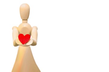 Wooden mannequin holds a heart in his hands, copy space. Concept of love and Valentine's Day. Woman with heart.