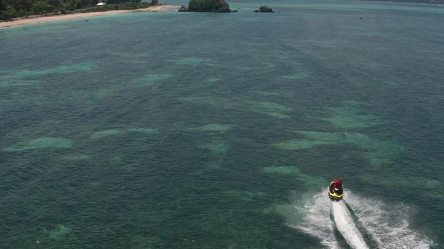 Top aerial view of jet ski racing on a crystal clear water. Extreme enjoying summer vacation. People are playing a water scooter in open sea waters. Watercraft adventure fresh day in summer holiday.