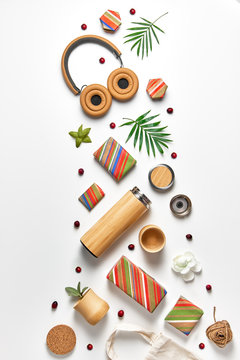 Zero waste wrapped stripy gift boxes, eco friendly gifts, bamboo cups and thermos flask. Geometric creative trendy top view on white neutral background with palm leaves and cranberry.