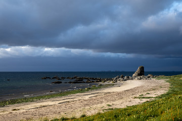 Storm clouds form over a sandy beach in Lofoten, Norway