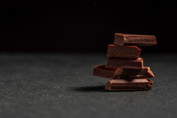 dark chocolate on a stone. Dark background