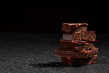 dark chocolate on a stone. Dark background