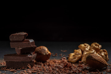 Dark chocolate in nuts on a stone. Dark background