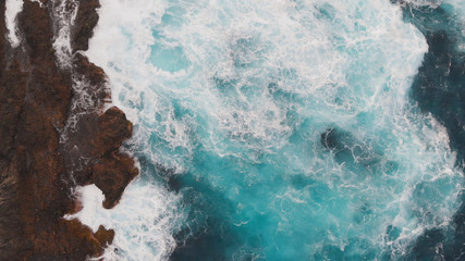 Top-down view of the ocean washing the large beautiful rocks on the Atlantic coast, Tenerife