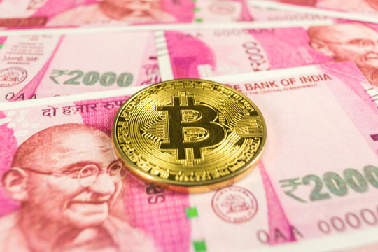 Cryptocurrency gold Bitcoin coin on a Indian rupee