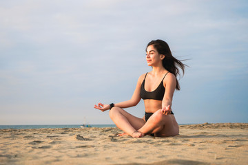 Fototapeta na wymiar woman is making yoga and meditation in the beach