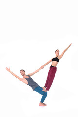 Young athletic couple practicing acroyoga. Balancing in pair.