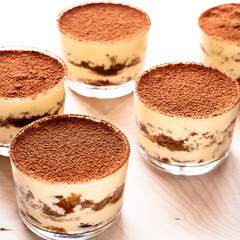 tiramisu in a glass decorated with coffee beans on a dark background