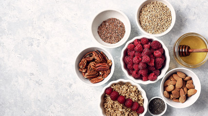 oatmeal for breakfast with raspberries, nuts and seeds. Good morning, health concept. Top view