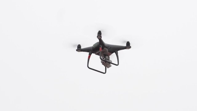 Drone flying aganst white background.