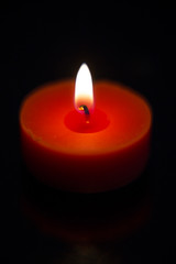Fototapeta na wymiar Candlelight in the black background