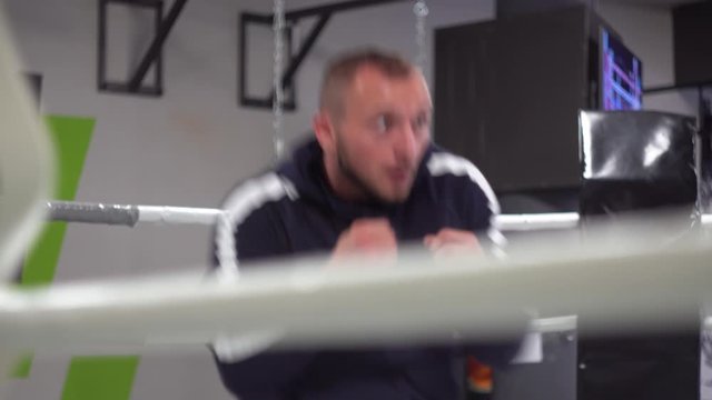Boxer man making strikes at fight training. Young muscular athlete fulfills kick