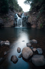 Nature around Lagoa do Vento and Risco waterfalls in Rabacal valley, Paul da Serra plateau, Madeira, Portugal. Smooth water around rocks in the stream, long shutter speed photo.
