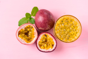 Fresh passion fruit and juice on pink background, top view