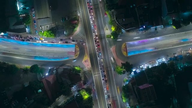 JAKARTA, Indonesia - December 18, 2019: Top down view hyperlapse of night traffic on highway with beautiful light trails. Shot in 4k resolution from a drone flying down