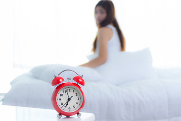 Woman stretching in bed after waking up, back view