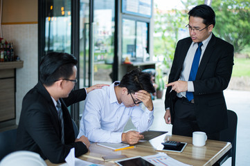 boss shouted and point his finger to employee because he very angry for reported sales decrease. employee is stressed and put hands on his head.