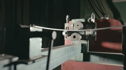 Forge workshop on table. Smithy manual production. Worker bends the metal rod on the wrought iron round bending machine. Manufacturing of a designer part from a metal rod. The blacksmith manufacture.