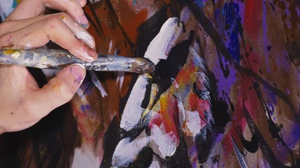 Artist designer draws an eagle on the wall. Craftsman decorator paints a picture with acrylic oil...