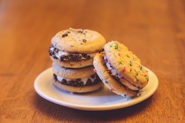 Chocolate chip and sugar cookie sandwich treats on a white plate