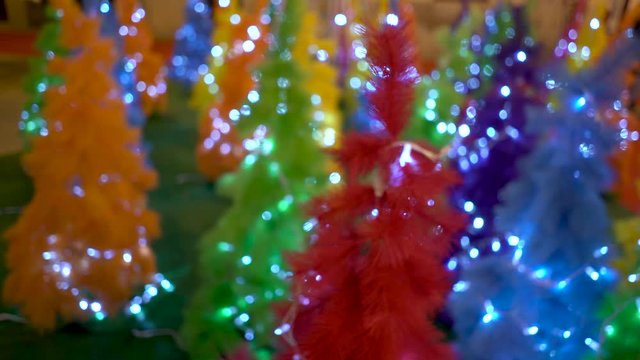 Lots of colorful lights adorning the Christmas trees, all colorful and full of decorations, blurred background, Bokeh. pan camera.
