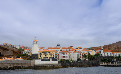 Obraz premium Tiny resort Quinta Do Lorde on Ponta de Sao Lourenoo peninsula. Masts of the mooring yachts visible over the pier that protects them from oceanic waves.