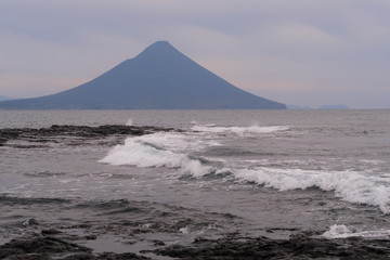 海上の打ち寄せる波と海に浮かぶ富士山