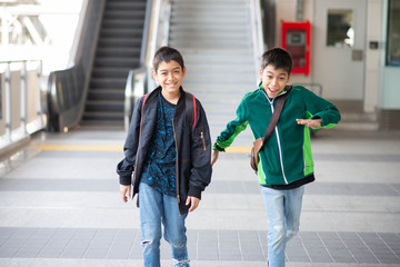 Obraz premium Little boy buying electric ticket and walking in the public sky train station with family