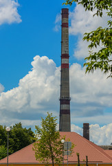 Pipe of a power plant on a background of sky and clouds.