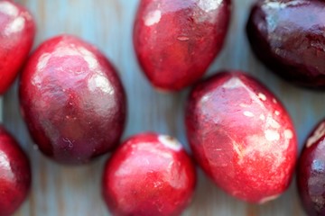 Macro view on group of bright glossy red cranberries on wooden surface