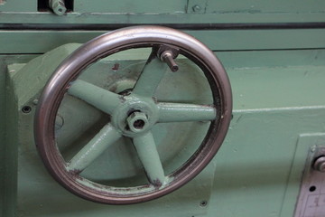 Big control wheel with handle on old metal-removal turning lathe machine tool on Machine tools factory workshop