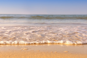 Soft wave from sea come to wet sand beach with blur clear sky background. With copy space for text or design