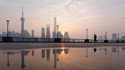 Poster Silhouet ochtendloper loopt op de beroemde bund zone met de zon opkomende shanghai stad achtergrond. © atiger