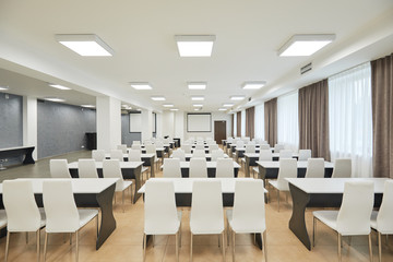 study in a modern style, in brown-white and beige tones, tables and chairs in a row