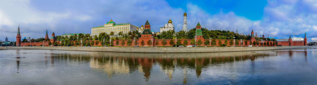 Panorama of the red Kremlin wall, tower and golden onion domes of cathedrals over the Moskva River in Moscow, Russia