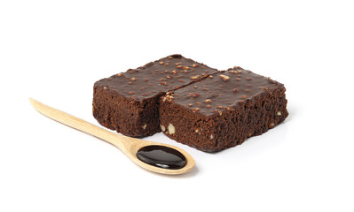 Chocolate brownie cake with Chocolate syrup in wooden spoon isolated on white background.